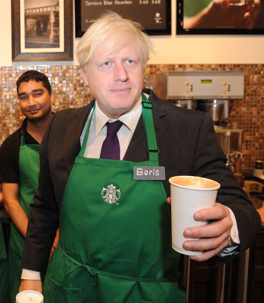 Being taught how to make a latte at a Starbucks branch in London (Stefan Rousseau/PA)