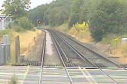 The level crossing barriers are still up as the train arrives at the crossing.