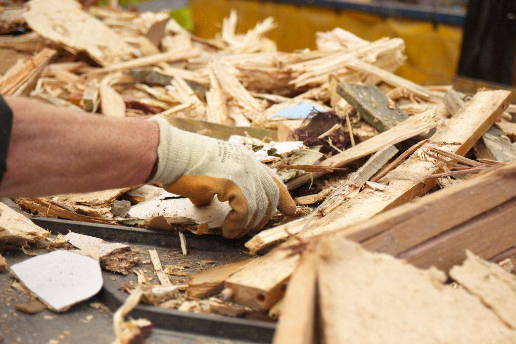 Workers sift through the wood production line to take out unwanted materials