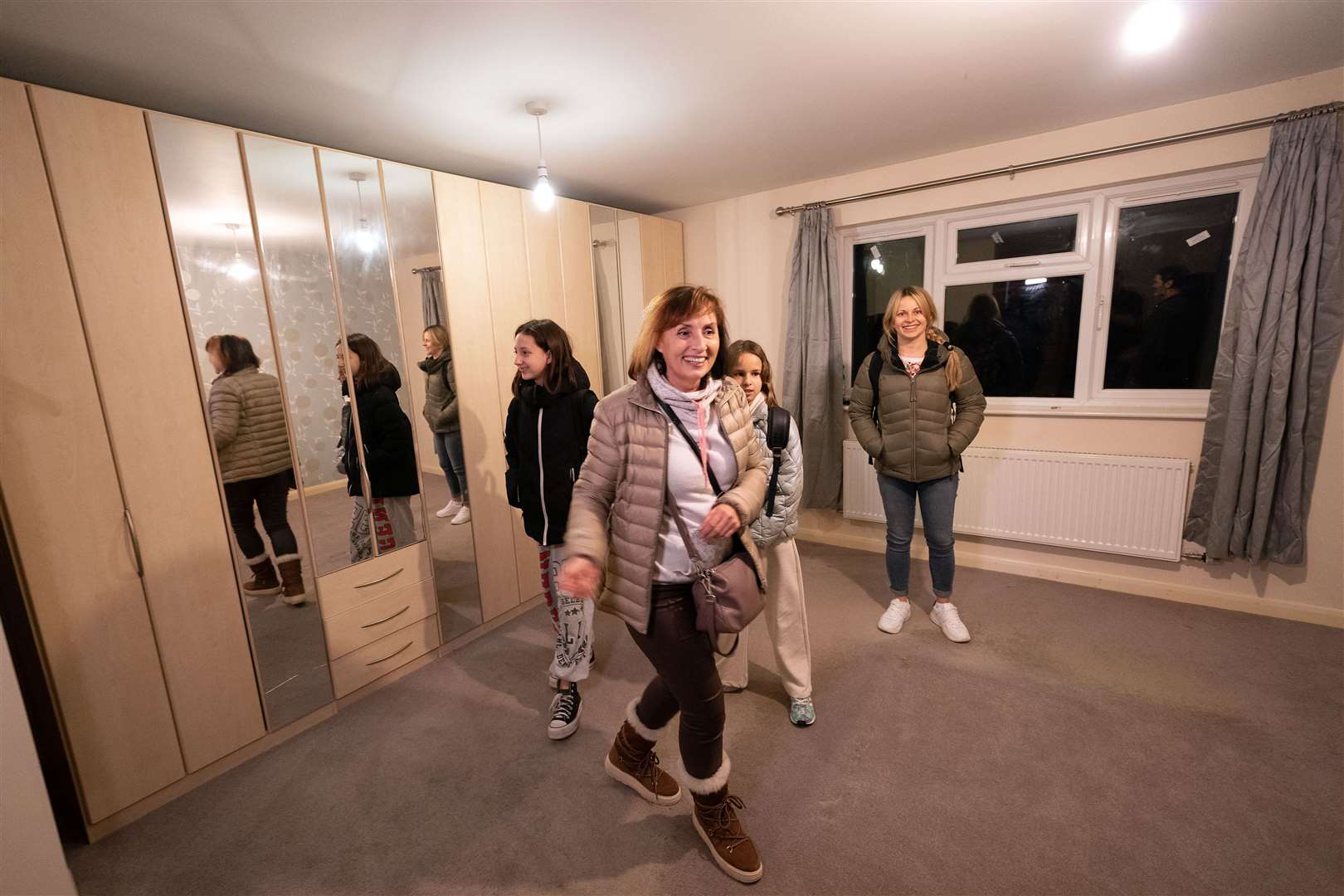 Iryna Starkova and her family look around one of the bedrooms in their new home in Caldecote near Cambridge. (Joe Giddens/ PA)