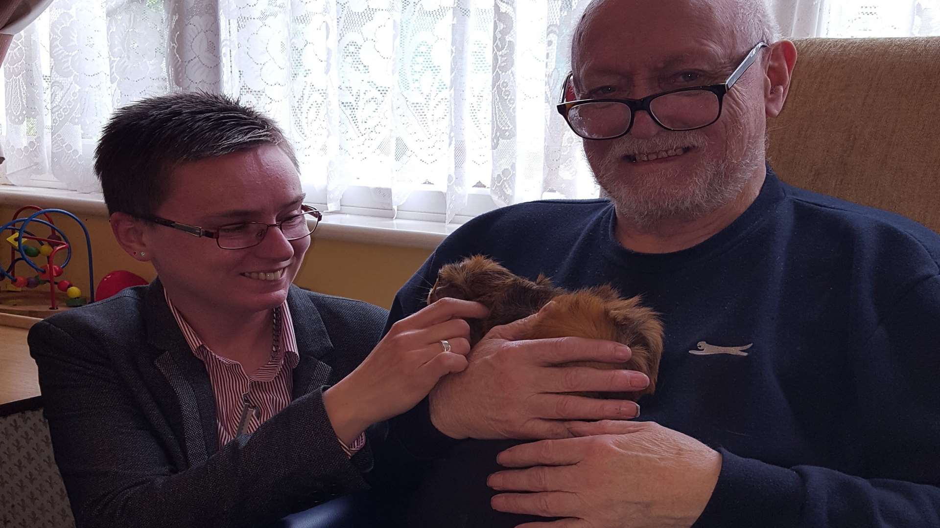 Jo Kula introduces 78-year-old Denis Knight to a guinea pig