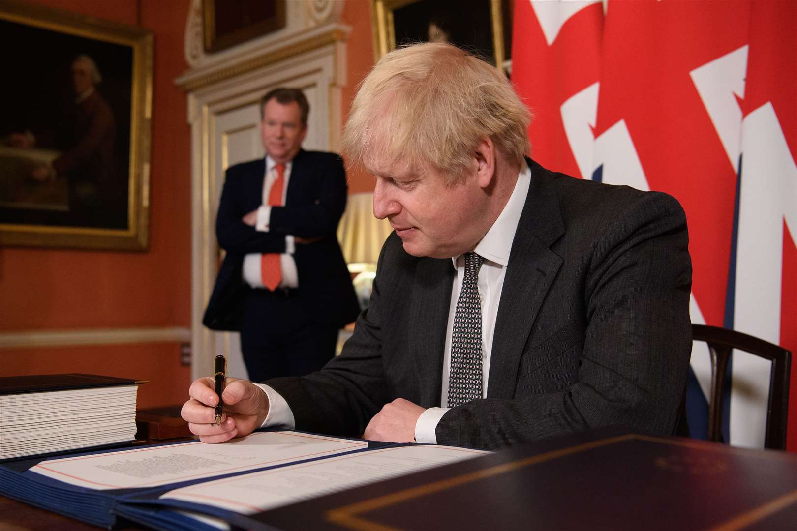 UK chief trade negotiator, David Frost looks on as Prime Minister Boris Johnson signs the EU-UK Trade and Co-operation Agreement at 10 Downing Street (Leon Neal/PA)