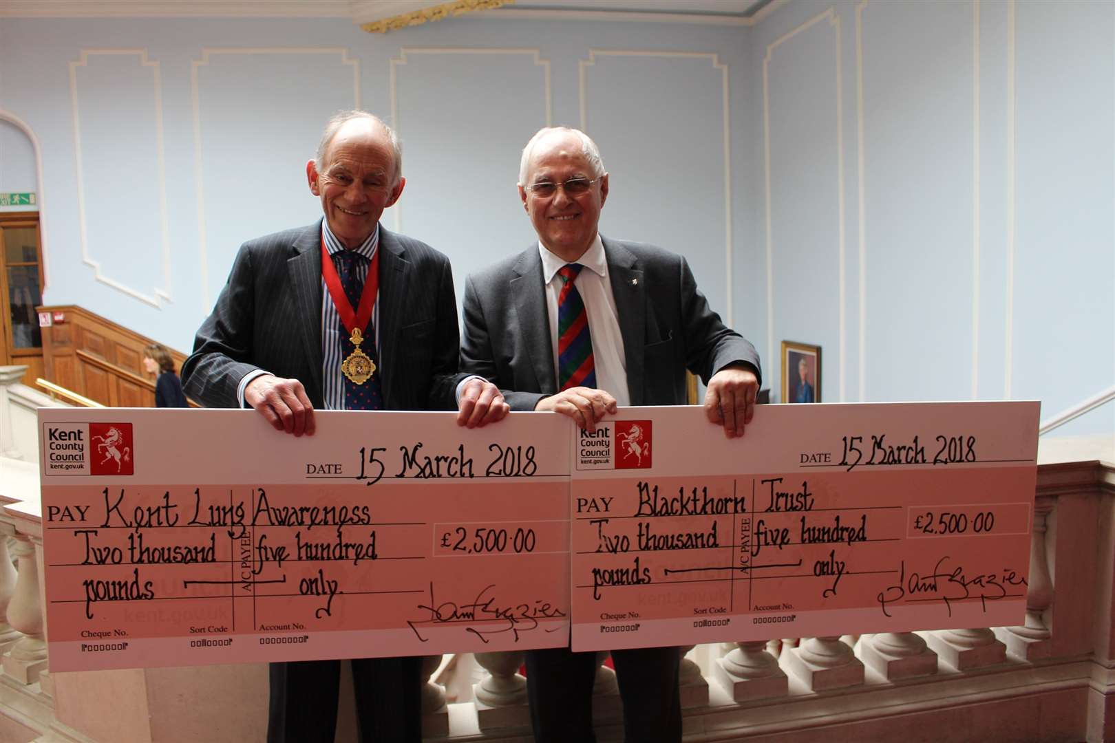 KCC chairman David Brazier presents Maidstone Studios owner and chairman Geoff Miles with the cheques for his chosen charities after winning the Kent Invicta Award