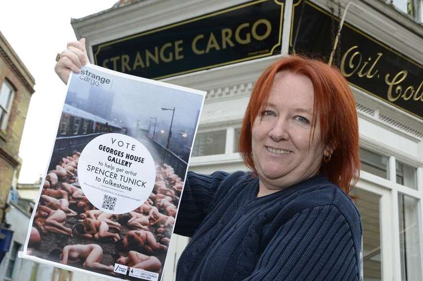 Artistic Director Brigitte Orasinski with a poster advertising the Spencer Tunick exhibition