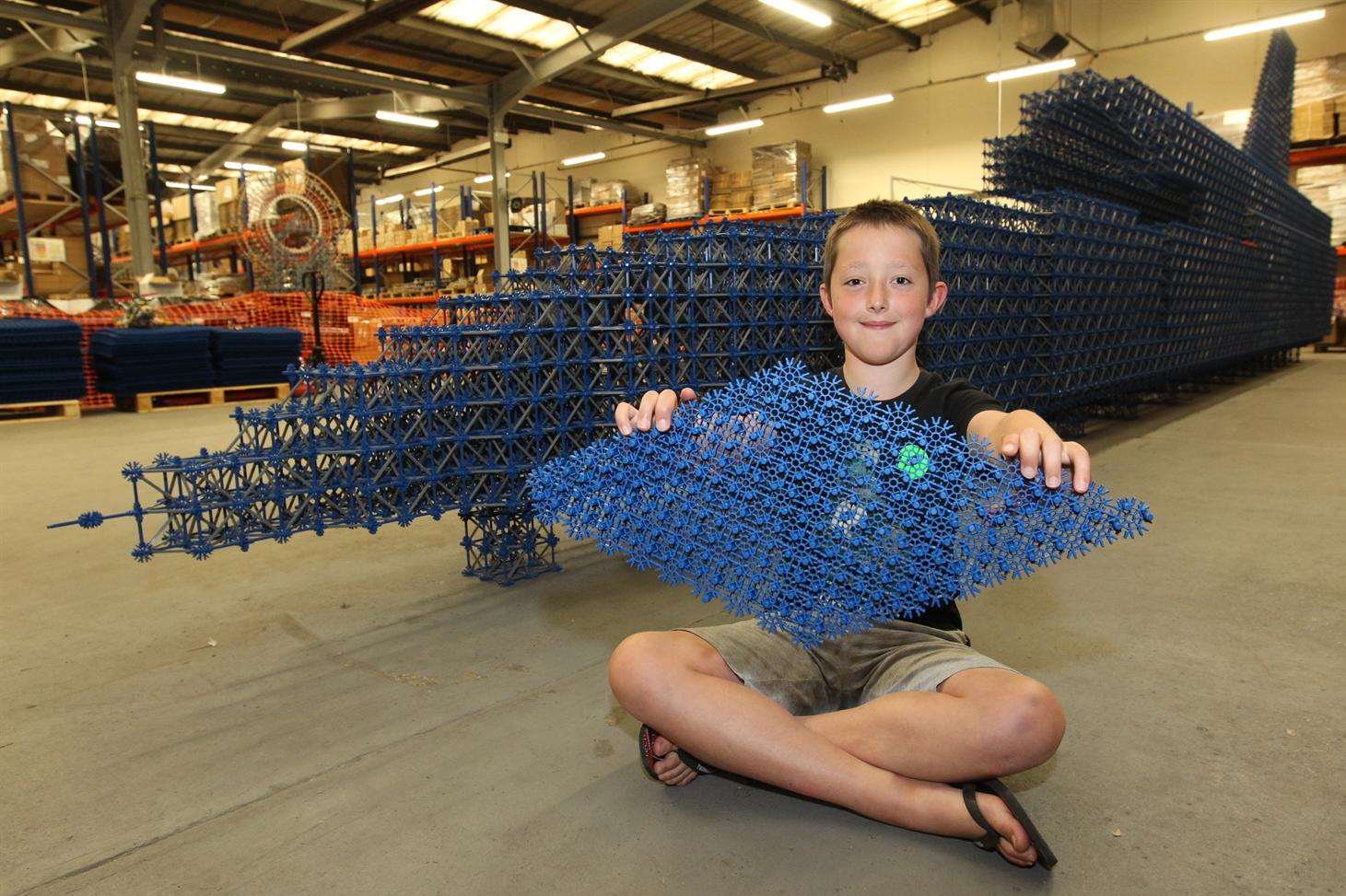 George Burgess, 11 with a piece of K'NEX that he and other volunteers used to help build a full size version of a land speed record car