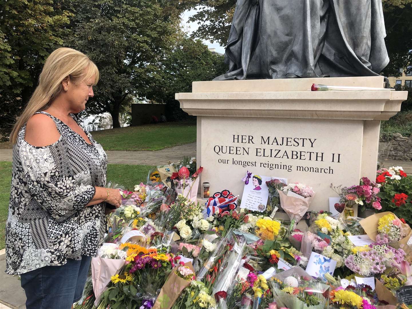 Kay Reynolds looking at the tributes left at the Queen Elizabeth II statue in Gravesend