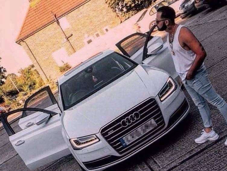 Mario Makula posing next to an Audi