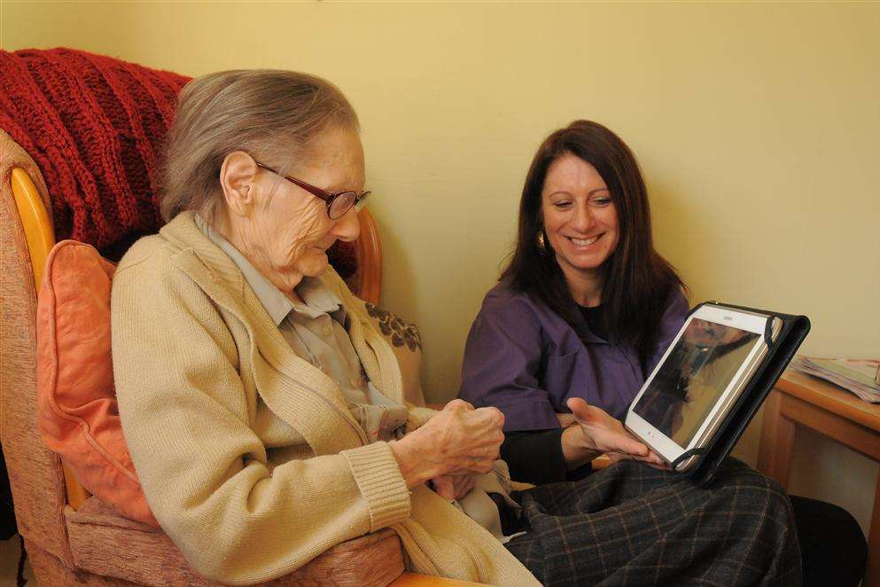 Elaine Bashford shows Tina Cornish Barton Court Care Home's new tablet computer