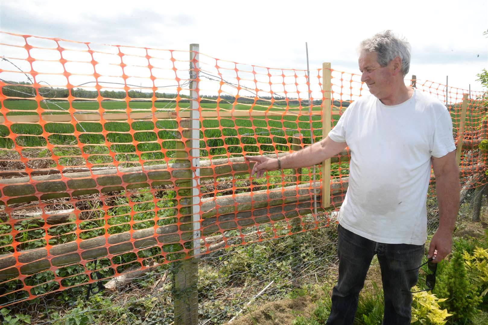 David Foulcer with the area of fencing that was cut to gain access to his garden