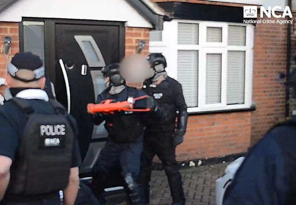 National Crime Agency officers raid a home and make arrests as part of an investigation into a people smuggling group