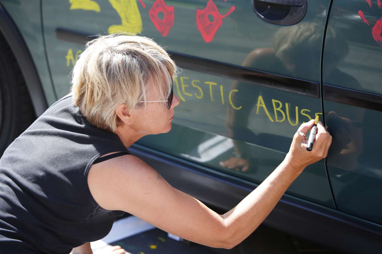 Bobby invites people to paint on his car.