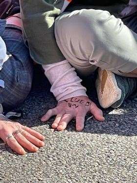 Protesters glued their hands to the road. Photo: David Wright
