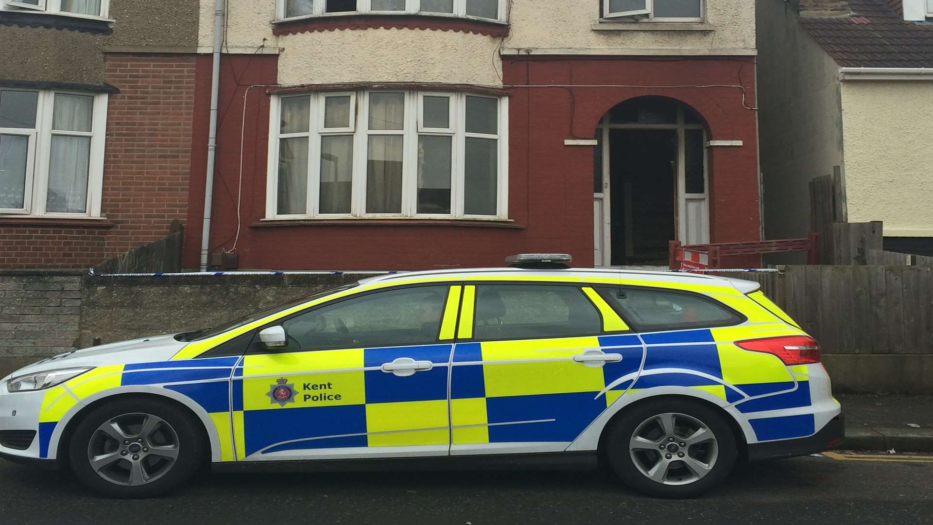 A police car parked outside the burnt out house in Clarence Road, Chatham
