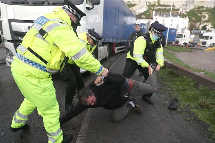 Police remove a man who lay in front of a lorry Picture: Andrew Matthews/PA