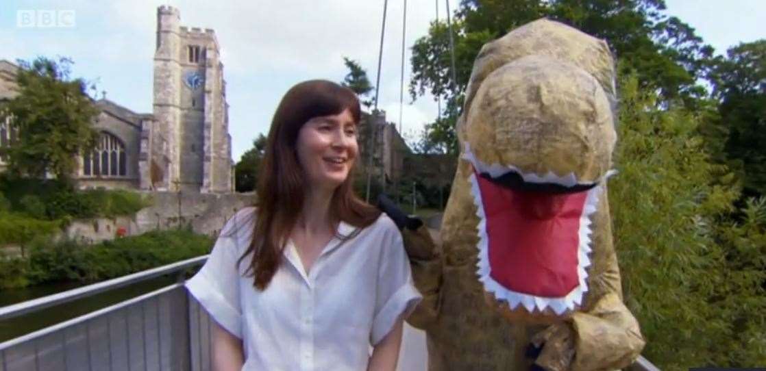 Natasha Raskin Sharp and the cuddly iguanodon on Lockmeadow Millennium Bridge in Maidstone Picture: BBC