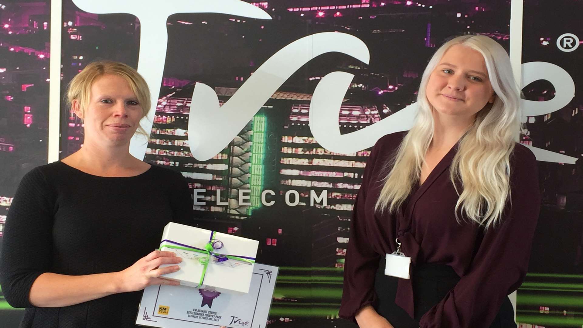Aimee Smith, biggest individual fundraiser at the KM Assault Course challenge, collects her prize of an iPad mini from Fern Hugill of True Telecom.