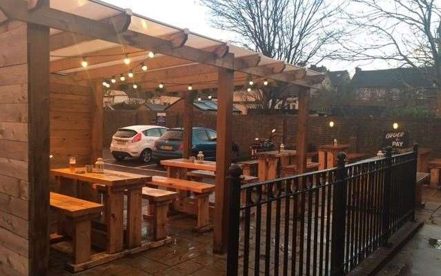 The covered smoking area is on the left hand side of the pub, next to the car park