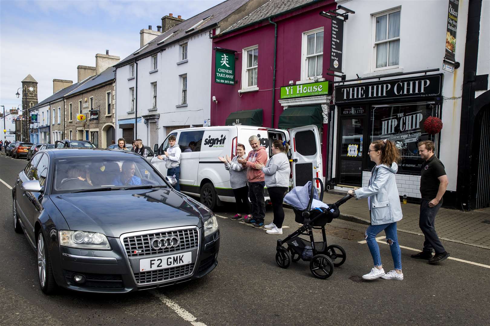 Geoffrey McKillop (in car) is greeted by well-wishers outside his chip shop in Bushmills (Liam McBurney/PA)