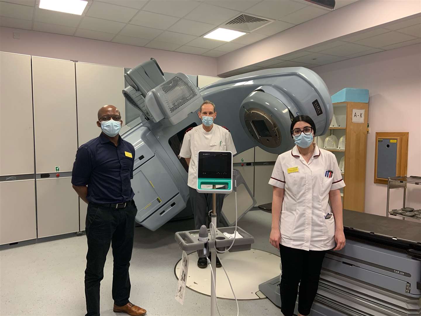 From left, Innocent Neshiri - radiotherapy clinical specialist; Geraint Rees - site specialist radiographer, and Elina Hajichristou - treatment radiographer with the new scanner. (44915935)