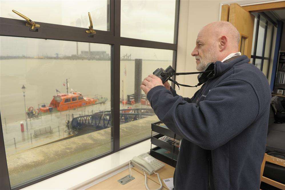 Steve King, duty helmsman, looks out over the pier jetty across the Thames