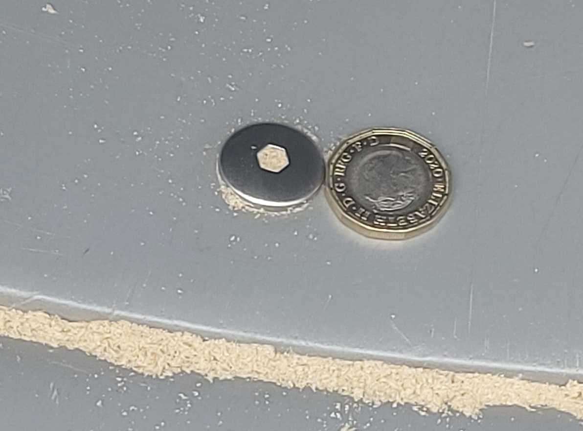 A pound coin shows how high the screws are on the slide