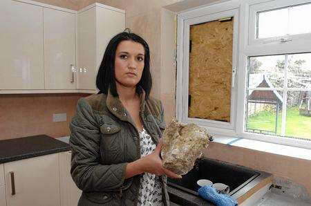 Sarah Strachan with the rock and the boarded up kitchen window at her home in North Street, Milton Regis