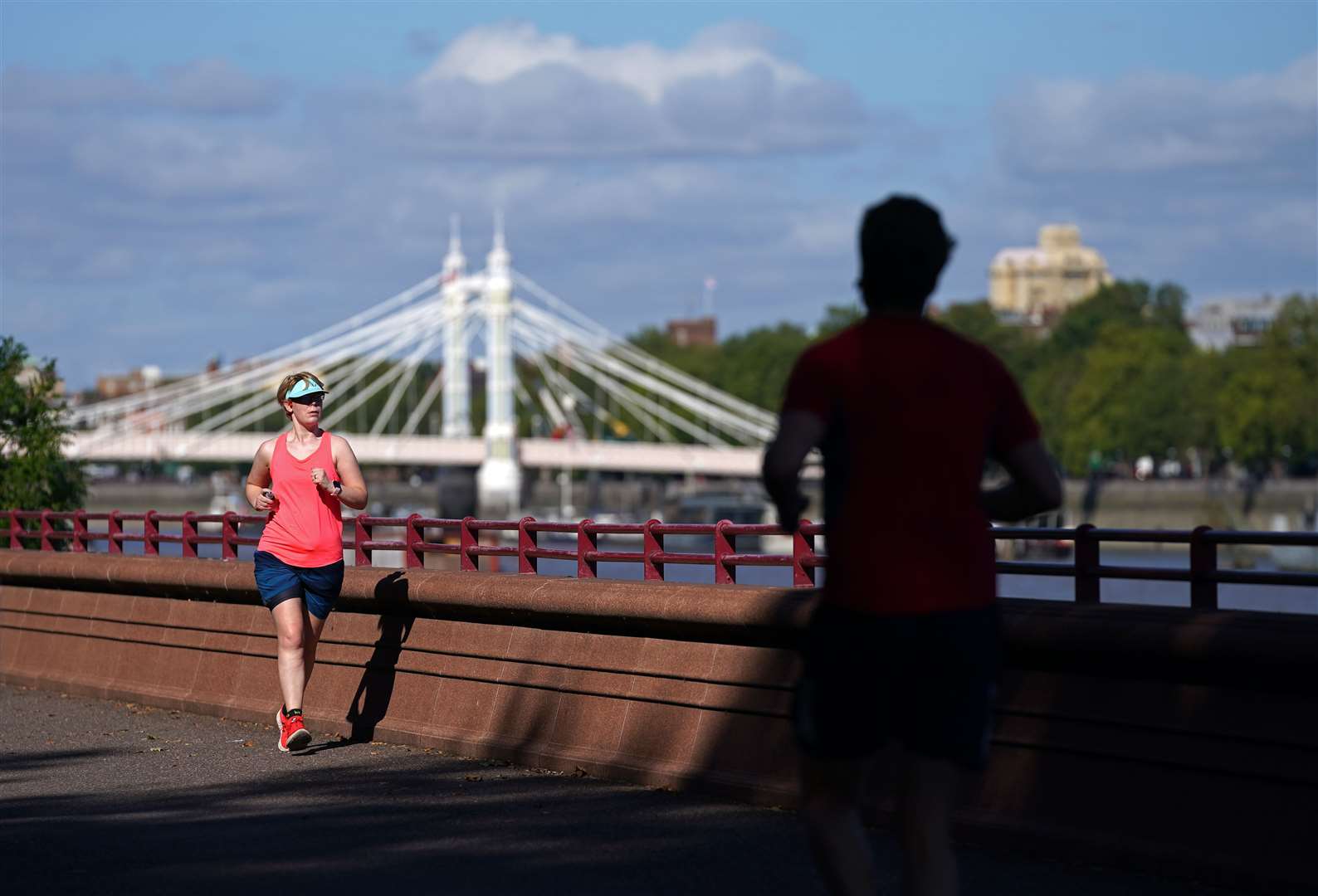 Runners in Battersea Park exercise next to the Thames in London (John Walton/:A)