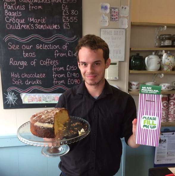 Liam West at Marie's Tea Room in High Street, Gravesend, holding up the cafe's popular lemon drizzle cake