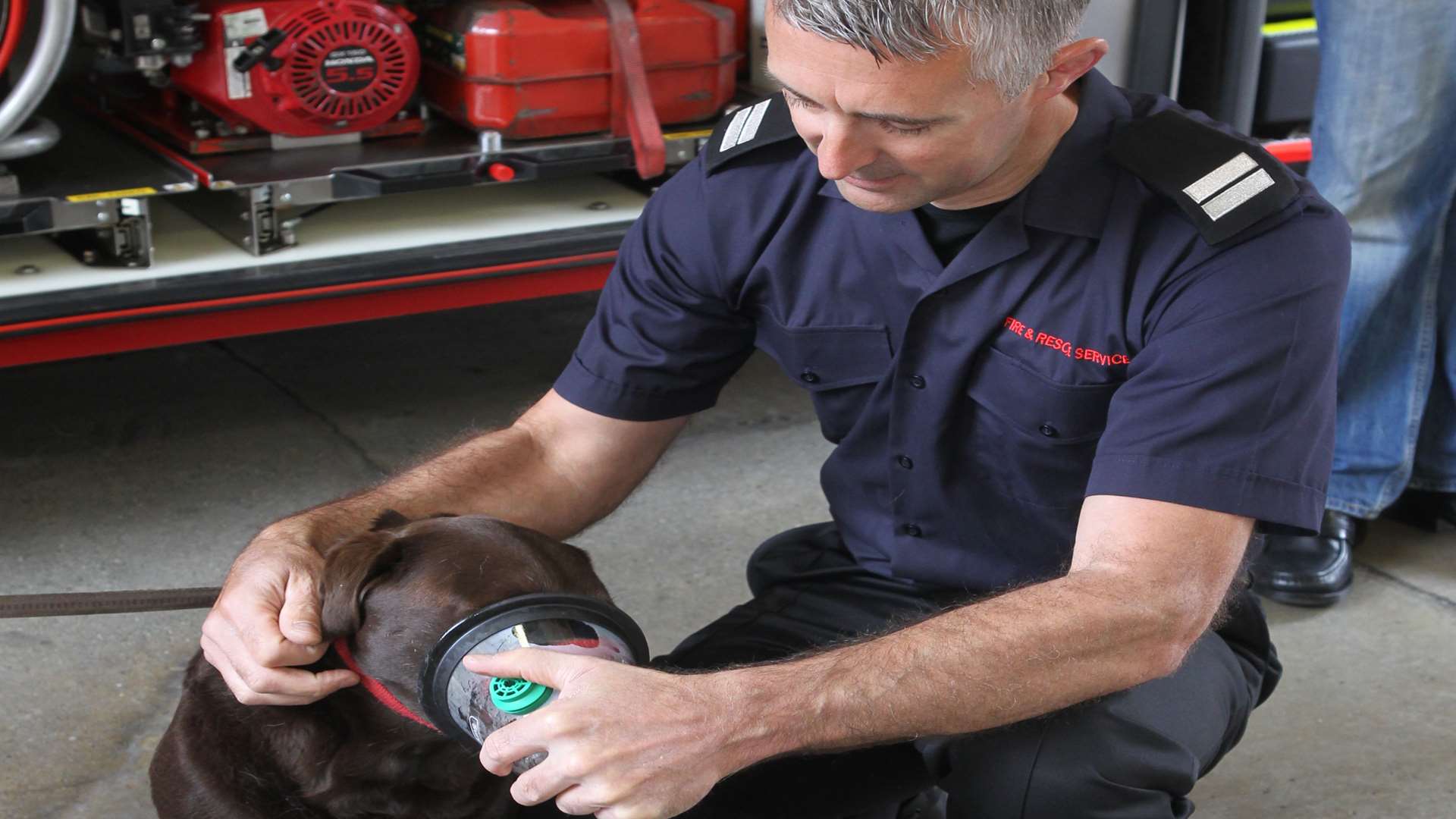Sheppey Fire Station crew manager Jim Ashby demonstrates the new animal oxygen mask on Cocoa