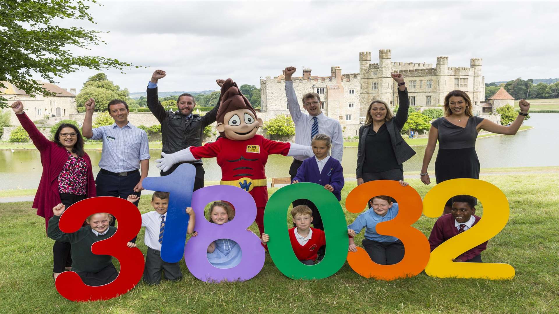 Green travel champions: pupils, supporters, and mascot Wowzer reveal the record breaking number of cars off the road at a celebration at Leeds Castle.