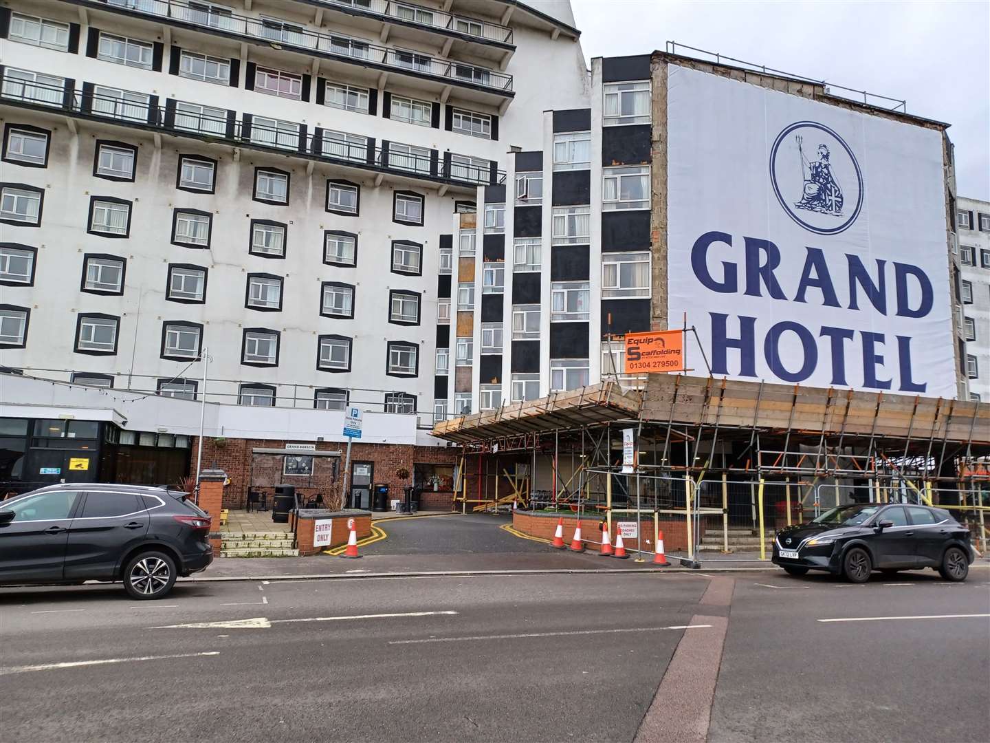 A huge material banner carrying the name Grand Hotel has appeared over the damaged frontage, where the Grand Burstin sign previously hung
