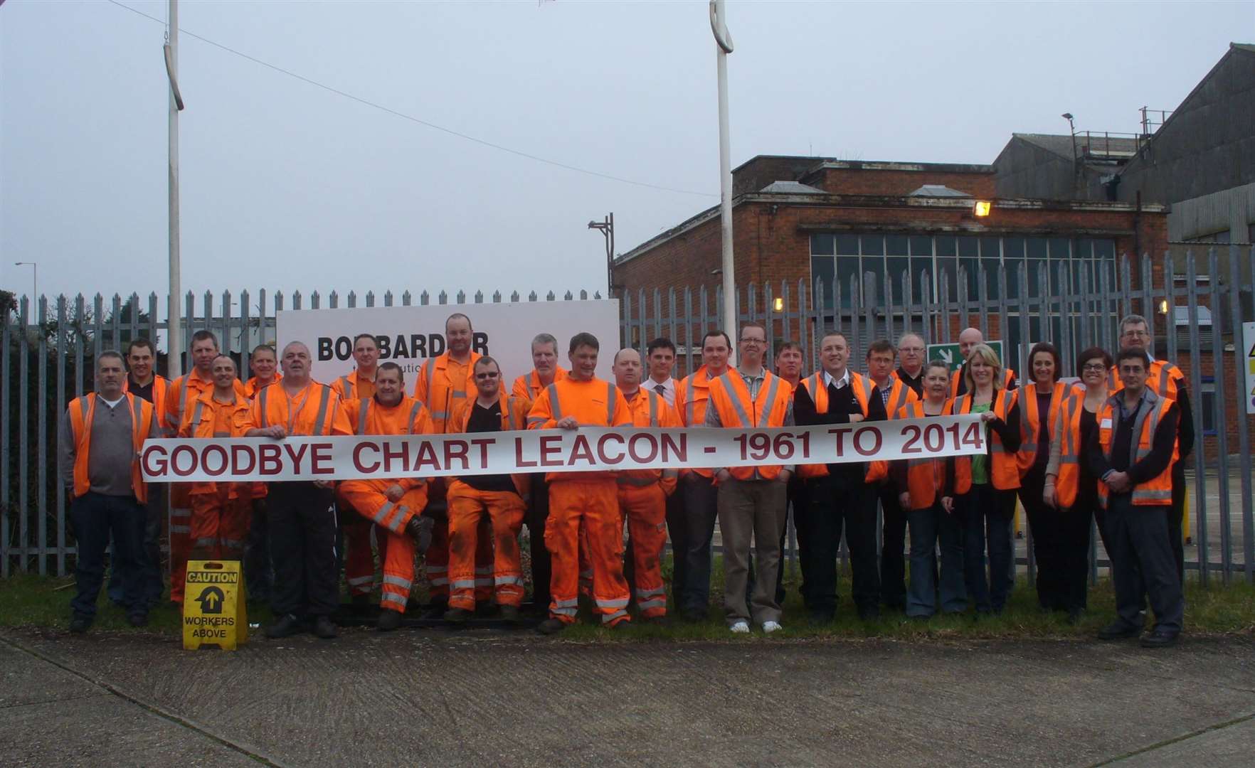 The remaining workforce of Bombardier's Chart Leacon rail depot gather to mark its closure in 2014