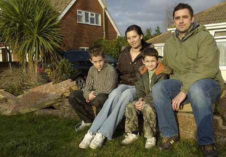 STORMY WEATHER: Joe, Joanne, Tom and Lee Palmer in front of their damaged house. Pictures: MATT McARDLE