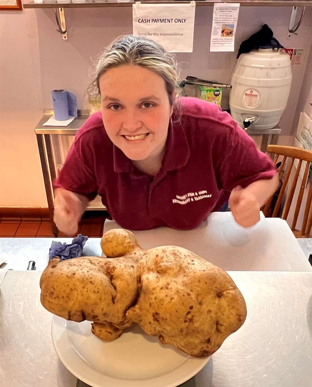 Roni Gill, 23, with the giant potato in Archie's Fish and Chip Shop in Minster in Thanet, September 4th 2023. Picture: SWNS