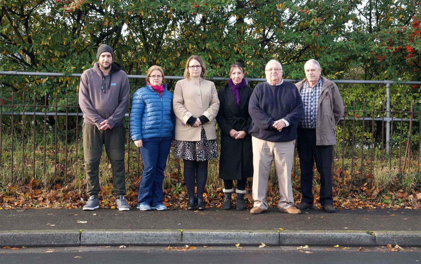 Councillor Kelly Grehan, third from left, with residents of Brent Way outside the decaying fence which separates their houses from the motorway