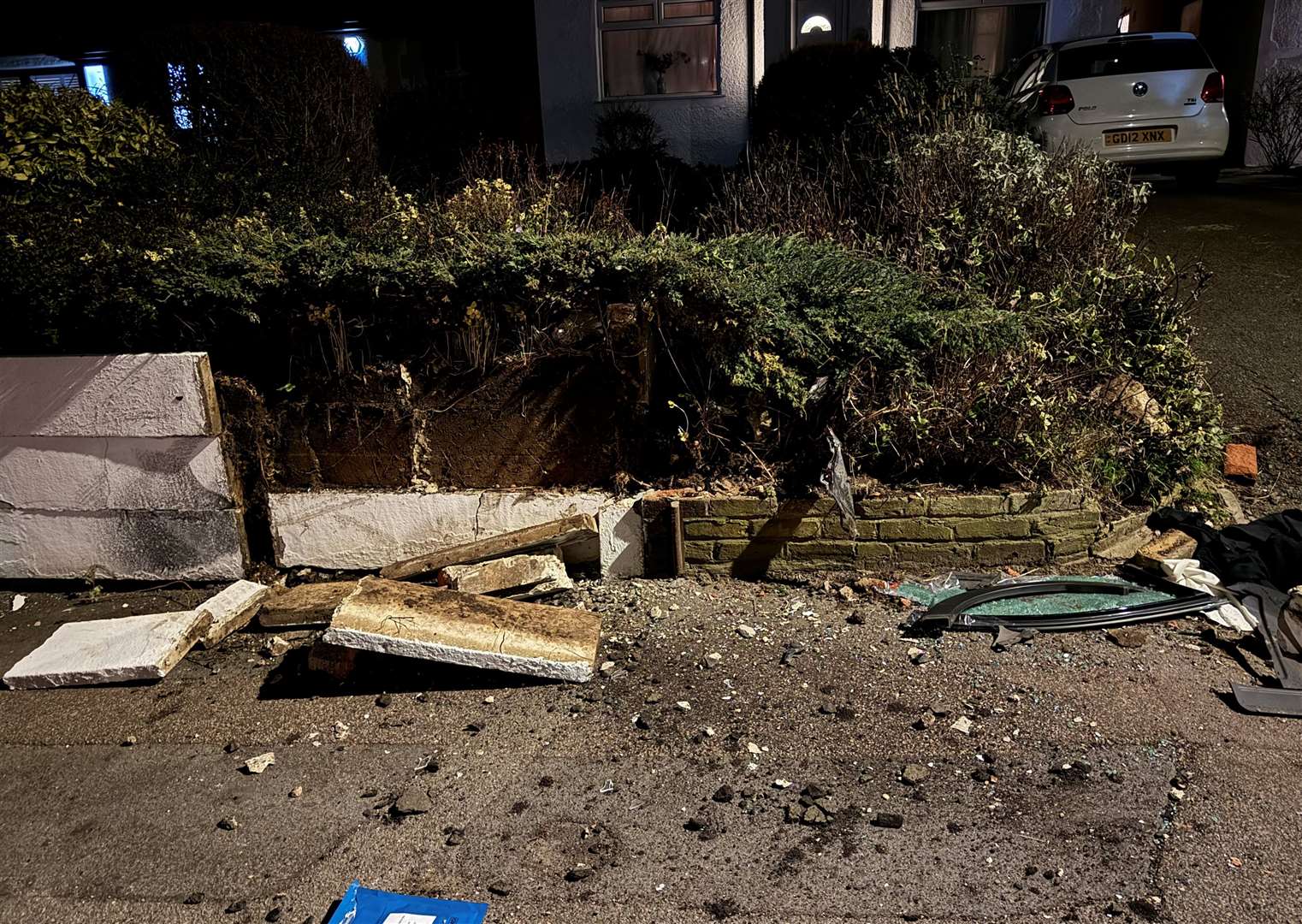 Debris and a smashed garden wall following the crash
