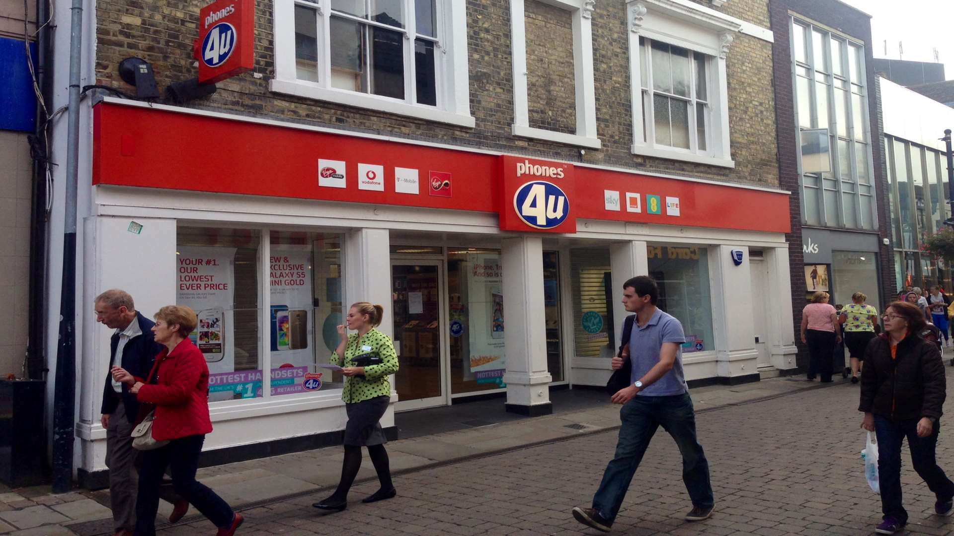 Shoppers pass the closed Phones 4U store in Week Street, Maidstone