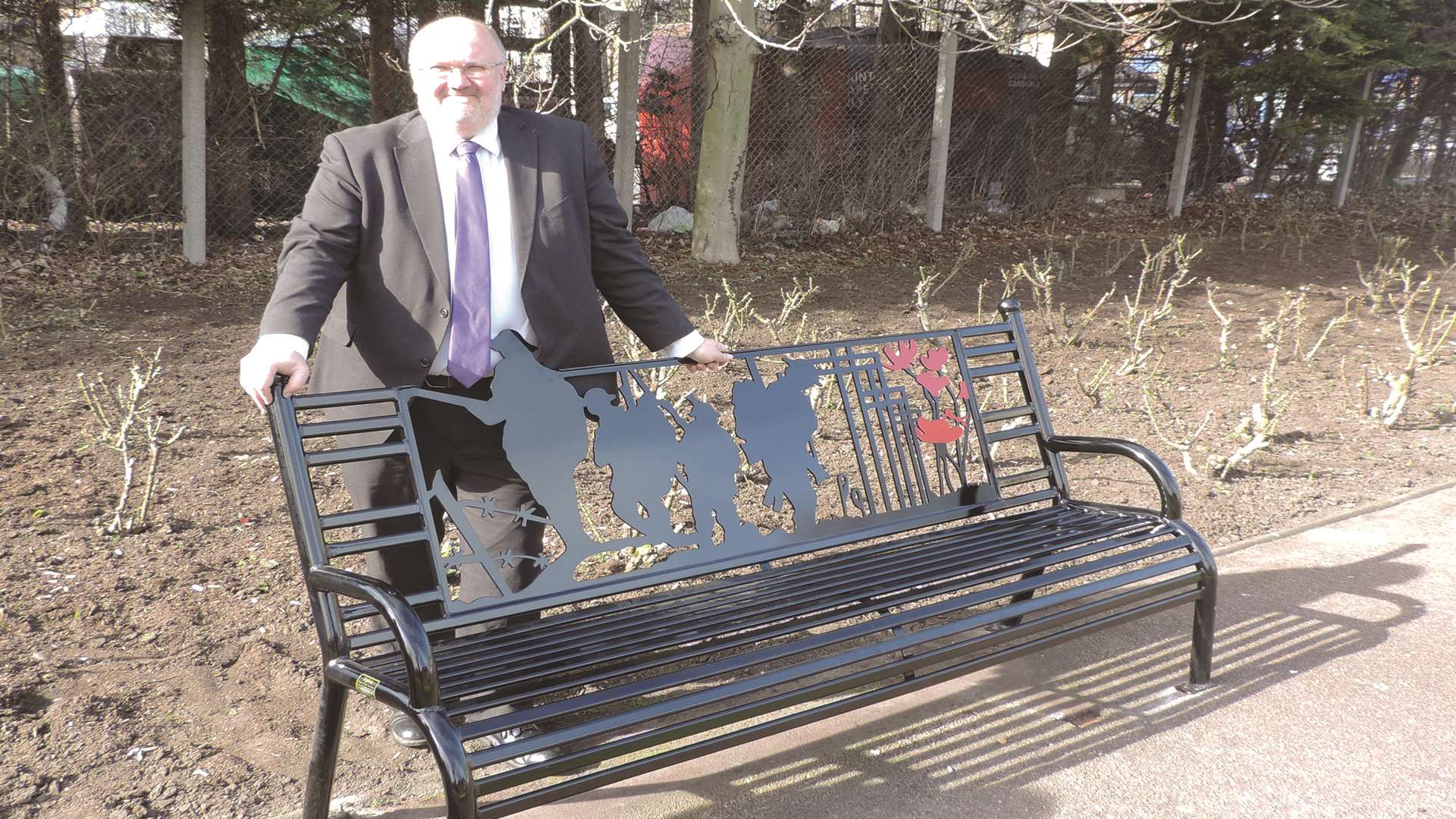Jeremy Kite, leader of Dartford council, posing with a new memorial bench dedicated to those who have died in the armed services