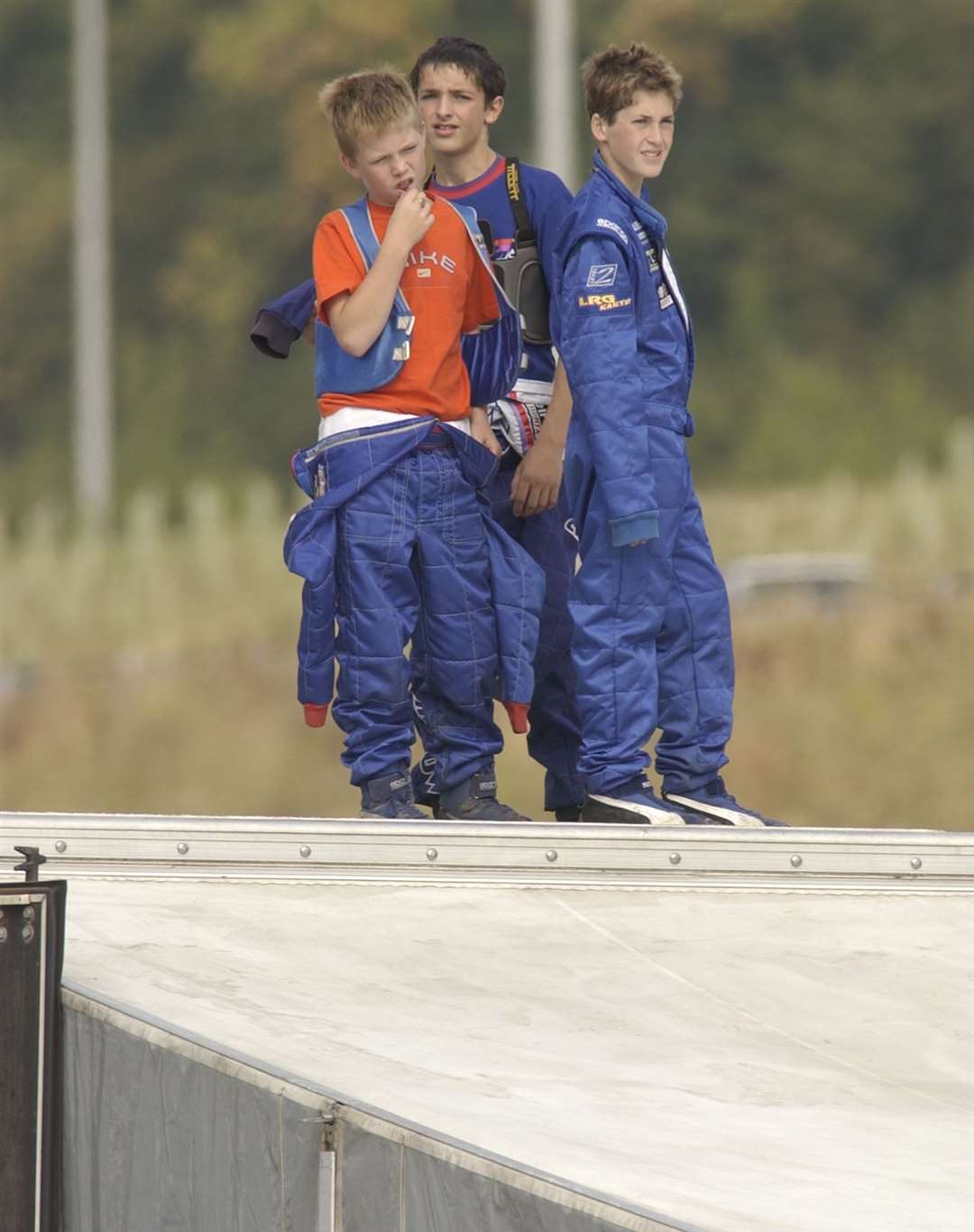 Young racers watch on from the paddock as they wait their turn on the track in September 2003