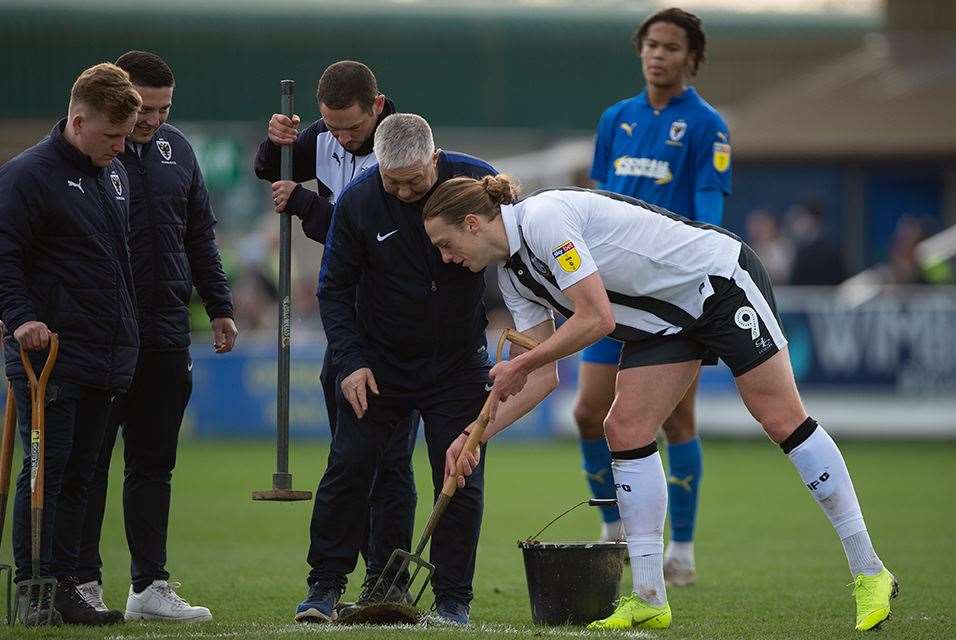 Tom Eaves helps repair the pitch Picture: Ady Kerry