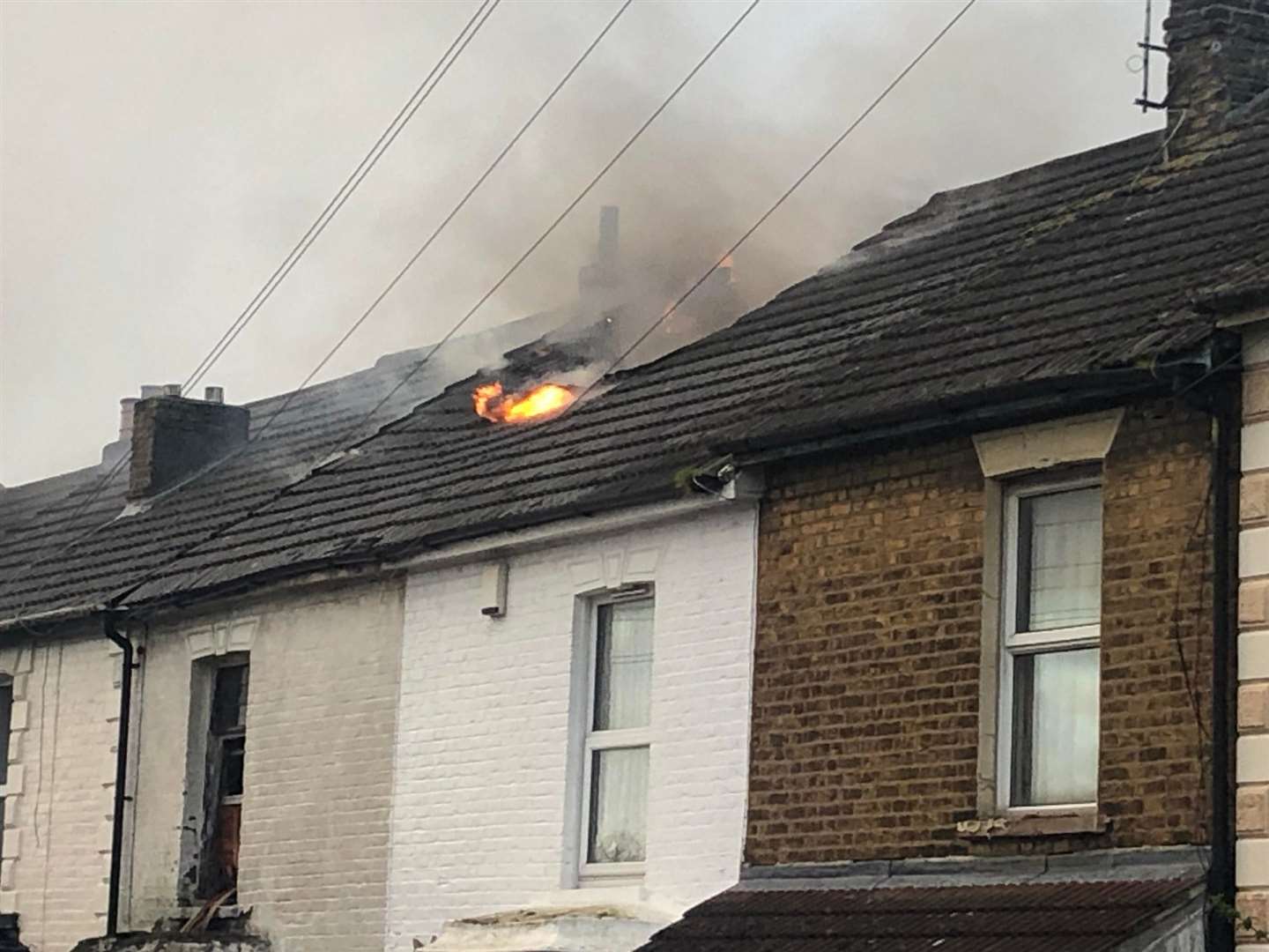 A fire can be seen slowing in the roof of the house in Skinner Street, Gillingham, on Monday evening