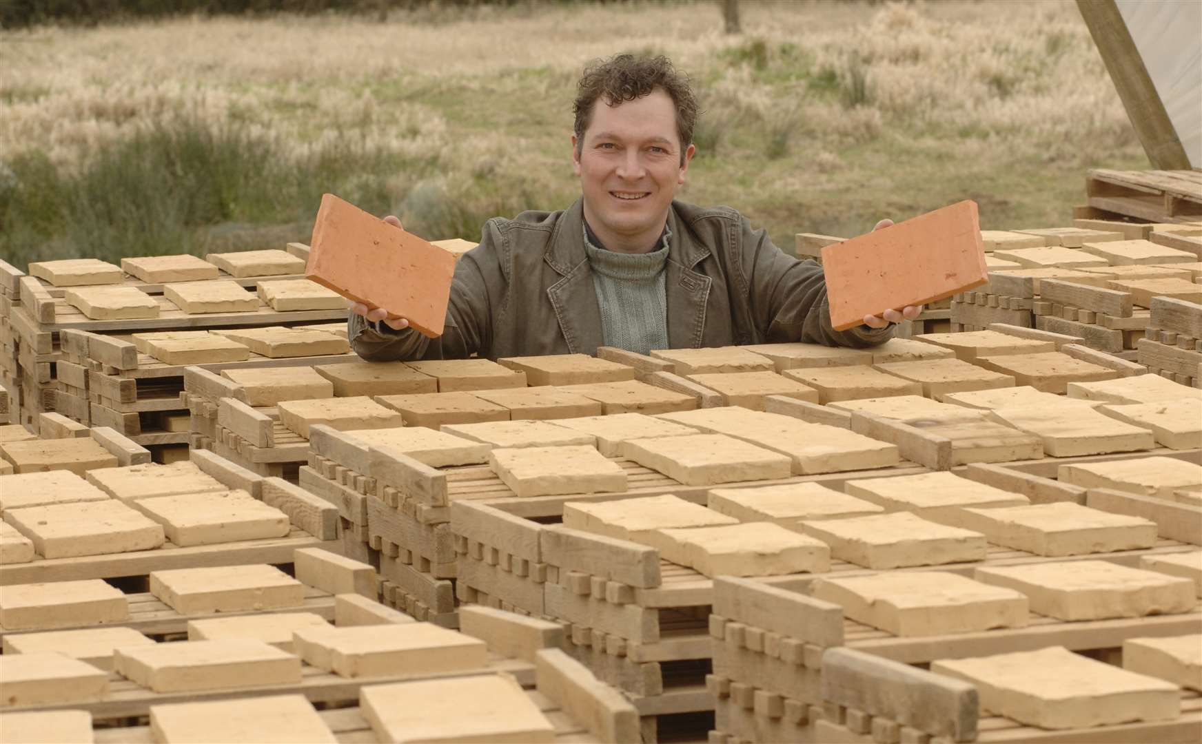 Richard Hawkes is pictured with some of the tiles that wer made for his environmentally friendly house