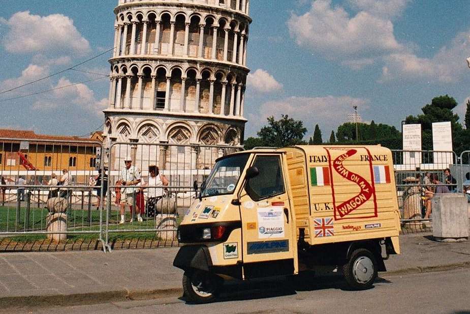 The three wheel Piaggio Ape that David used to cross Europe next to the Leaning Tower of Pisa