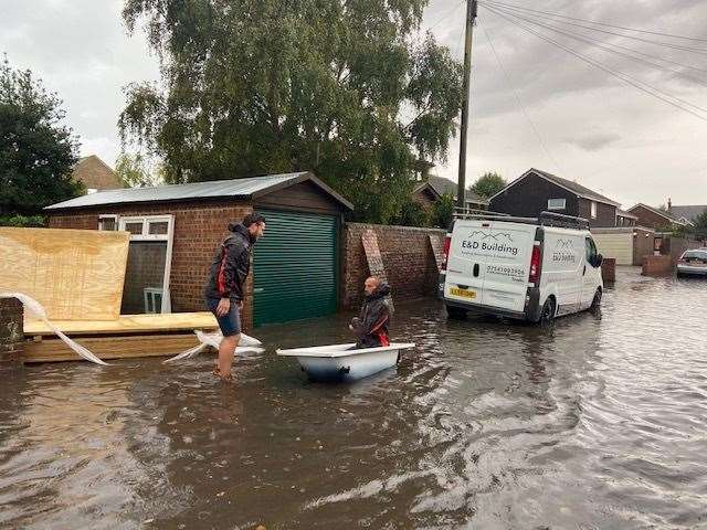 Two men get to work helping to protect a home in Middle Deal Road Picture: Hannah Price