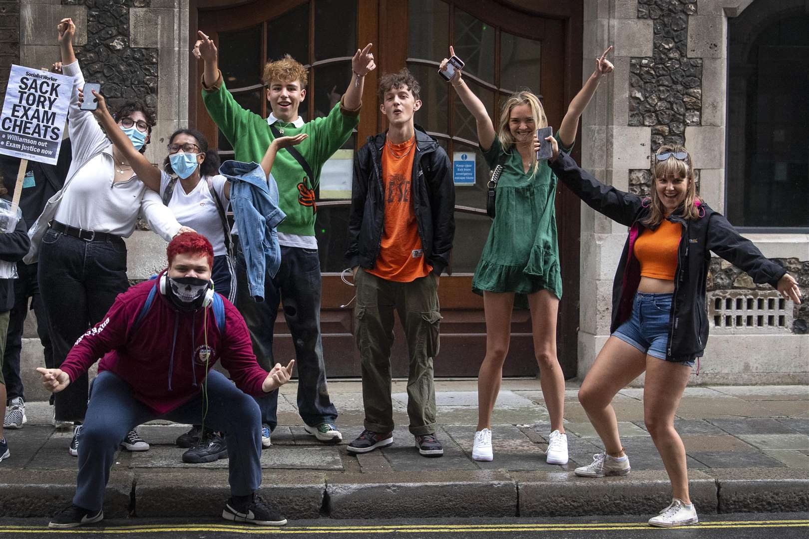 A-level students celebrate outside the Department for Education in London after it was confirmed that candidates in England will be given grades estimated by their teachers (Victoria Jones/PA)