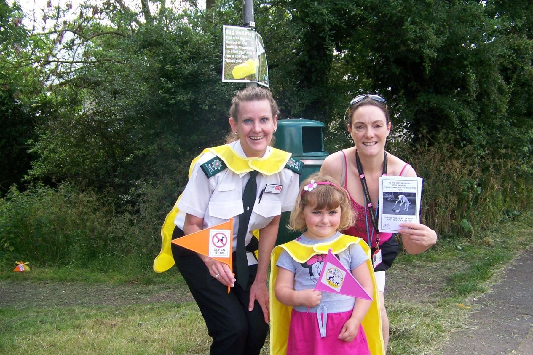 Holly, age 4 from Hildenborough puts on a scooper hero cape to support The Big Scoop 2014 with Viv Hickmott, KCC Community Warden (left) and Tamsin Ritchie, Tonbridge & Malling Borough Council’s Environmental Projects Coordinator.