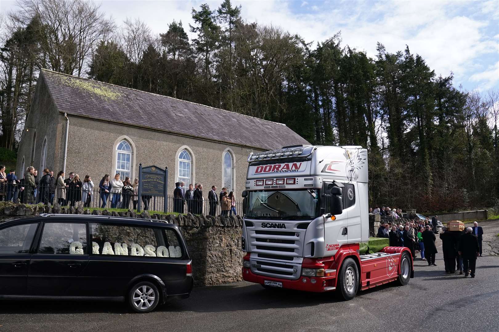 The coffin of Keith Morrison is taken from the back of a truck (Brian Lawless/PA)