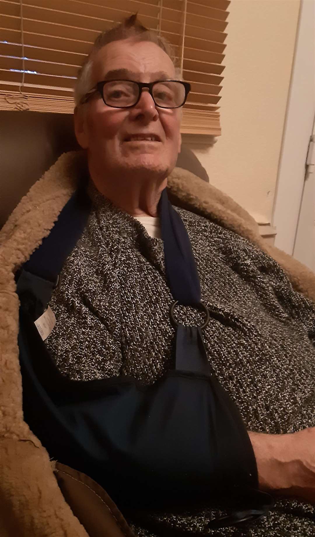 Dale Howting at home with his sling and broken collarbone after taking a tumble on his mobility scooter