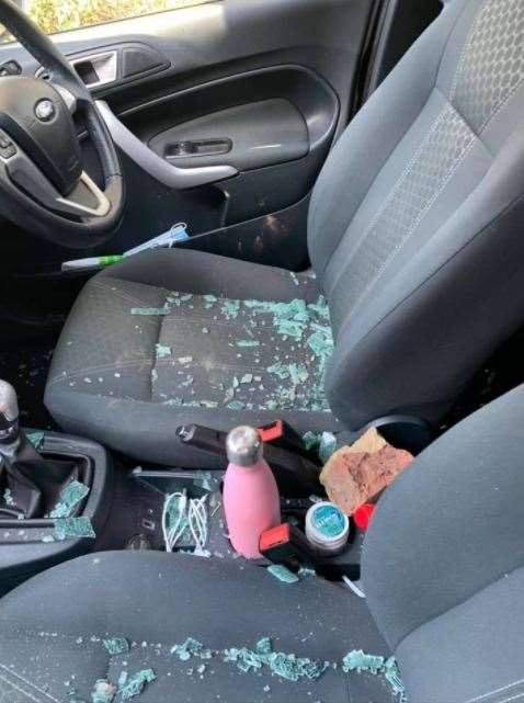 The brick smashed through the window and landed between the two seats of the student's car