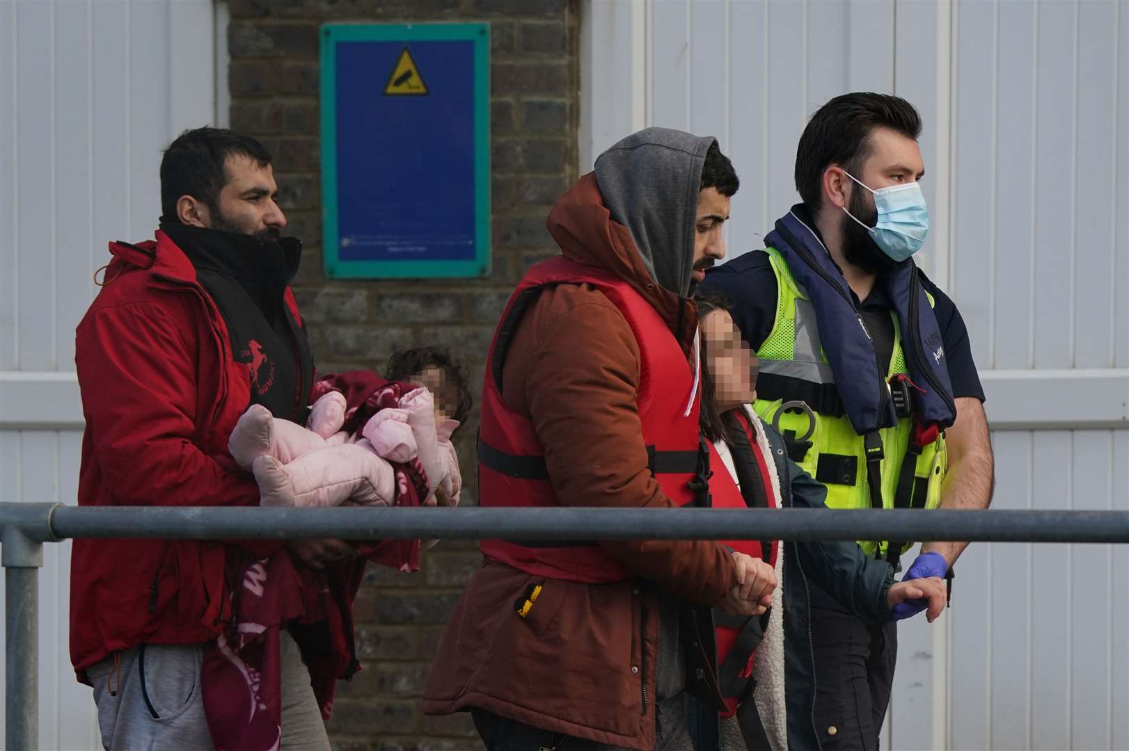 People are escorted by Border Force officers after being brought in to Dover, Kent, following a small boat incident in the Channel (Gareth Fuller/PA)